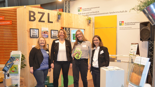 Vier Personen an einem Messestand Vier Personen an einem Messestand