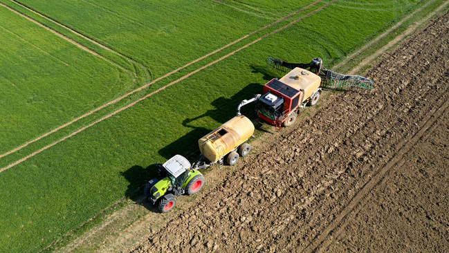Traktor auf Feld bei Düngung Traktor auf Feld bei Düngung